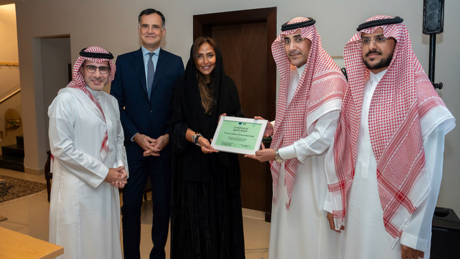 Princess Lamia bint Majed Saud Al-Saud, secretary-general of Alwaleed Philanthropies, leads the presentation of an honorary certificate to Abdullah Alahmari, CEO of Konoz initiative, and Yazeed Albader, associate producer of “Horizon.” (AN photo/ Huda Bashatah)