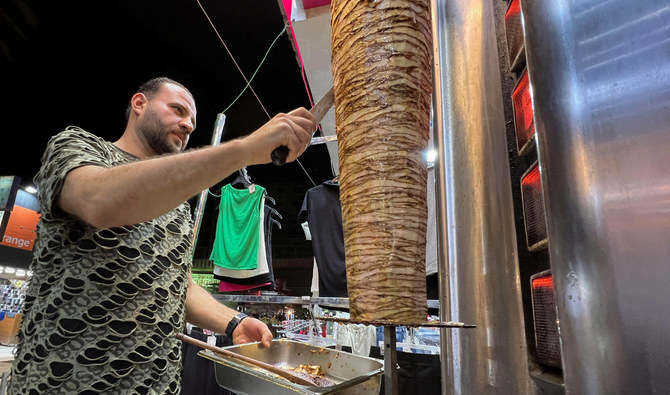 Basem Abu Al-Awn — a Gaza war refugee — owns ‘The Restaurant of Rimal Neighborhood’ in Cairo, managed by Ahmed Awad who prepares the meat. (Reuters)