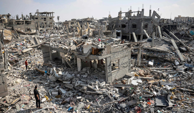 People inspect the damage amid the rubble of buildings destroyed during Israeli bombardment in Khan Yunis, on the southern Gaza Strip on April 16, 2024. (AFP)