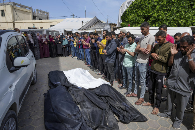 Mourners pray over the bodies of Palestinians who were killed in an Israeli airstrike in Nuseirat, at the Al Aqsa hospital in Deir al Balah, Gaza Strip, on April 27, 2024. (AP)