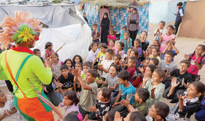 A man dressed as a clown entertains children at a makeshift school in a camp for displaced Palestinians in Deir Al-Balah in the central Gaza Strip. (AFP)