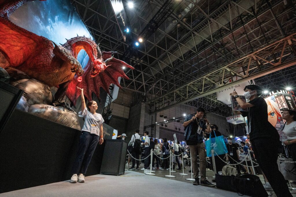 A visitor poses in front of a display for Dragon's Dogma at Makuhari Messe in Chiba City. (AFP)