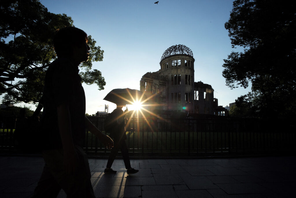 This photo taken on August 5, 2023 shows pedestrians walking past the Atomic Bomb Dome beside the Hiroshima Peace Memorial Park in Hiroshima. (AFP)