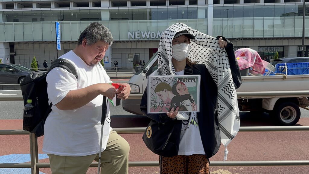 Many young people of different nationalities wore Arabic-style keffiyehs in the Tokyo sunshine. (ANJ)