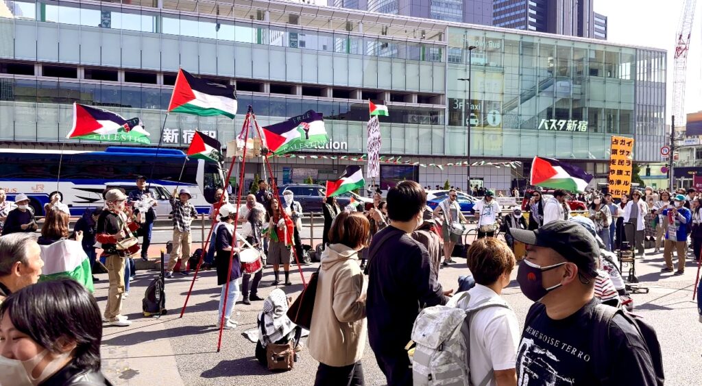 Many young people of different nationalities wore Arabic-style keffiyehs in the Tokyo sunshine. (ANJ)