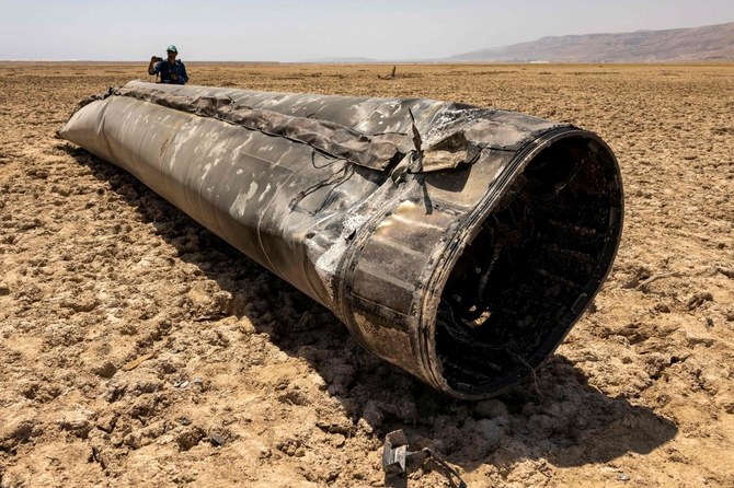 Photographers stand by the remains of a missile that landed on the shore of the Dead Sea, a week after the missile barrage fired by Iran on April 13, on April 21, 2024. (AFP)