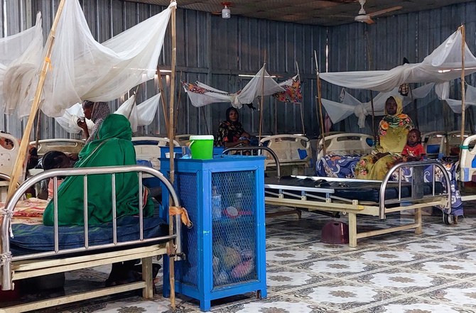 Women and a children sit waiting at a nutrition centre at the Kalma camp for the displaced just outside Nyala, the provincial capital of South Darfur state, on November 20, 2022. (File/AFP)