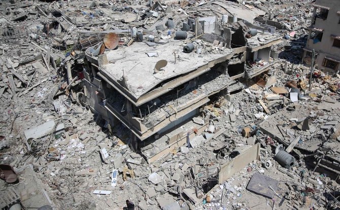 A Palestinian man walks on building rubble in a devastated area around Gaza’s Al-Shifa hospital on April 3, 2024, amid the ongoing conflict between Israel and the Palestinian Hamas militant group. (AFP)