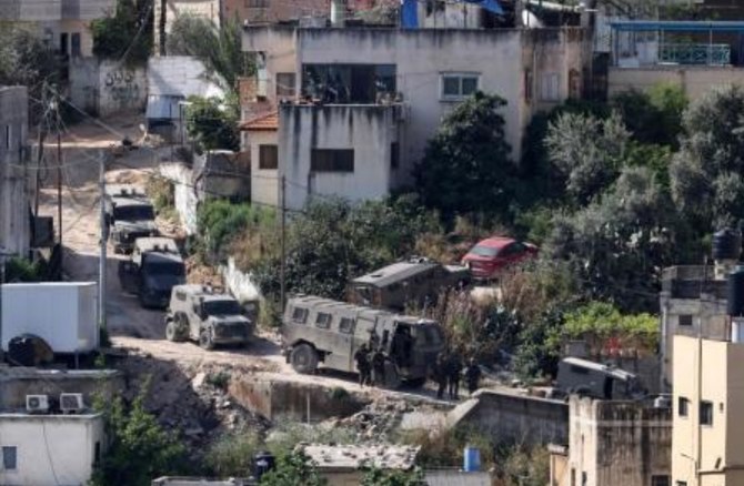 Israeli soldiers line up on a street during a raid in the Nur Shams camp for Palestinian refugees in the occupied West Bank on Apr. 20, 2024. (AFP)