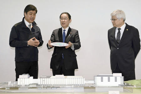 Japanese Prime Minister Fumio Kishida (center), is briefed as he visits a plant of the Taiwan Semiconductor Manufacturing Co. in Kikuyo town, Kumamoto prefecture, southern Japan Saturday, April 6, 2024. At right is Taiwan Semiconductor Manufacturing Company CEO C.C. Wei. (Kyodo News via AP)