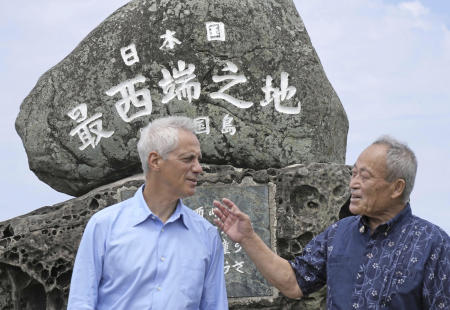 US Ambassador to Japan Rahm Emanuel (left), and Yonaguni Mayor Kenichi Itokazu talk in front of a monument indicating Japan's westernmost point on Yonaguni Island in Okinawa prefecture, southern Japan Friday, May 17, 2024. (Kyodo News via AP)