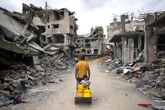 Palestinian man pulls a cart on a road lined with destroyed buildings in Khan Yunis in the southern Gaza Strip amid the ongoing conflict between Israel and the Hamas movement. (File/AFP)