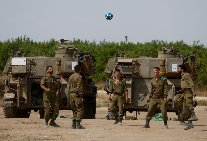 Israeli soldiers play next to military vehicles near the Israel-Gaza border on May 2, 2024, as they await results of talks being brokered by third parties to end the conflict with Hamas. (Reuters)