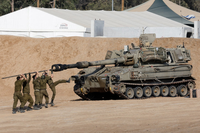 Israeli soldiers clean the barrel of a mobile artillery unit near the Israel-Gaza border on April 30, 2024, as they await results of talks being brokered by third parties to end the conflict with Hamas. (Reuters)