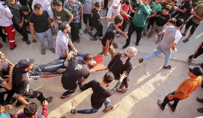 Palestinians transport an injured man pulled from the rubble of a house destroyed in an Israeli strike in the center of Rafah in the southern Gaza Strip on May 5, 2024, amid the ongoing conflict between Israel and the Palestinian Hamas movement. (AFP)