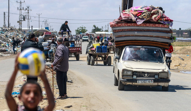 Displaced Palestinians who left with their belongings from Rafah in the southern Gaza Strip following an evacuation order by the Israeli army, arrive to Khan Yunis on May 6, 2024, amid the ongoing conflict between Israel and the Palestinian Hamas movement. (AFP)