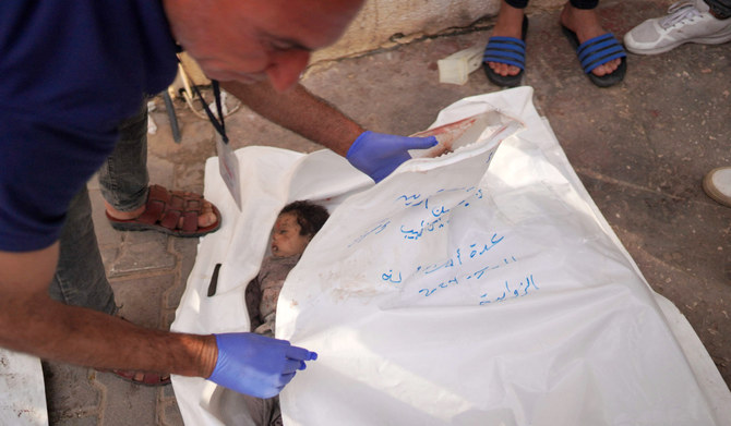 A Palestinian man covers the bodies of children killed in Israeli bombardment, in the yard of the Al-Aqsa Martyrs Hospital in Deir al-Balah in the central Gaza Strip on May 11, 2024, amid the ongoing conflict between Israel and the Palestinian Hamas movement. (AFP)