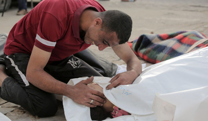 A Palestinian man reacts over the body of a child killed in Israeli bombardment, in the yard of the Al-Aqsa Martyrs Hospital in Deir al-Balah in the central Gaza Strip on May 11, 2024, amid the ongoing conflict between Israel and the Palestinian Hamas movement. (AFP)