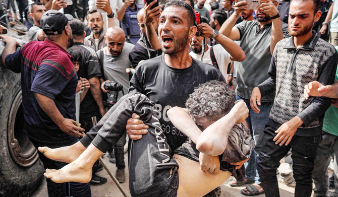 A man carries the body of a child victim that was recovered from beneath the rubble of a collapsed building in the aftermath of Israeli bombardment in Nuseirat in the central Gaza Strip on May 14, 2024 amid the ongoing conflict in the Palestinian territory between Israel and Hamas. (AFP)