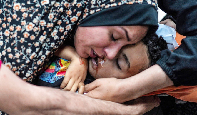 A woman mourns over the body of a child who was injured during bombardment on a displaced persons camp, at a trauma ward at the Aqsa Martyrs Hospital in Deir el-Balah in the central Gaza Strip on May 11, 2024 amid the ongoing conflict in the Palestinian territory between Israel and Hamas. (AFP)