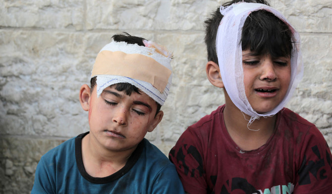 Injured Palestinian boys react as their family wait to identify the bodies of relatives killed in Israeli bombardment, in the yard of the Al-Aqsa Martyrs Hospital in Deir al-Balah in the central Gaza Strip on May 11, 2024, amid the ongoing conflict between Israel and the Palestinian Hamas movement. (AFP)