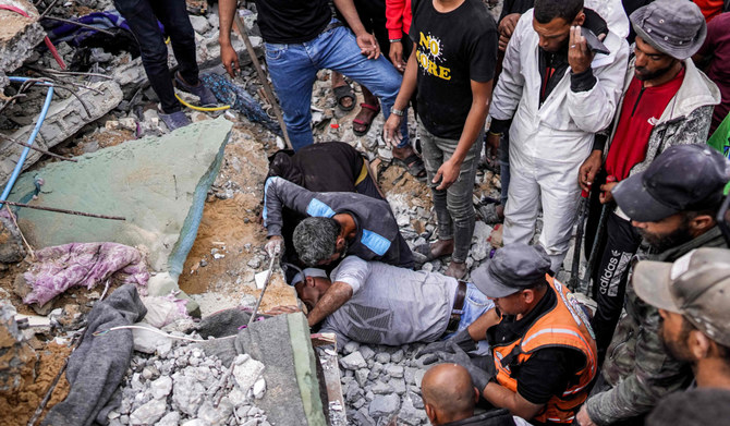 People gather around as volunteers try to rescue survivors and recover the bodies of victims from beneath the rubble of a collapsed building in the aftermath of Israeli bombardment in Nuseirat in the central Gaza Strip on May 14, 2024 amid the ongoing conflict in the Palestinian territory between Israel and Hamas. (AFP)