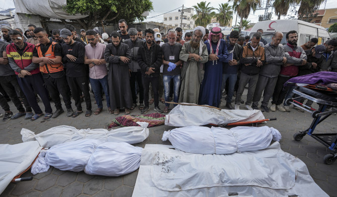 Palestinians pray by the bodies of people killed during Israeli airstrikes in the Gaza Strip, next to the morgue in Deir al Balah, Tuesday, May 14, 2024. (AP)
