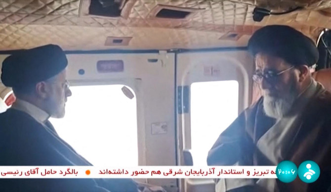 Video footage shows Iran's President Ebrahim Raisi (L) with an unidentified memeber of his delegation on board a helicopter in the Jofa region of the western province of East Azerbaijan. (AFP)