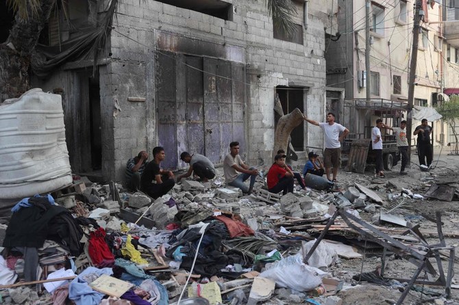 Palestinians sit by the rubble of a family house that was hit overnight in Israeli bombardment in the Tal Al-Sultan neighborhood of Rafah in southern Gaza on May 20, 2024. (AFP)