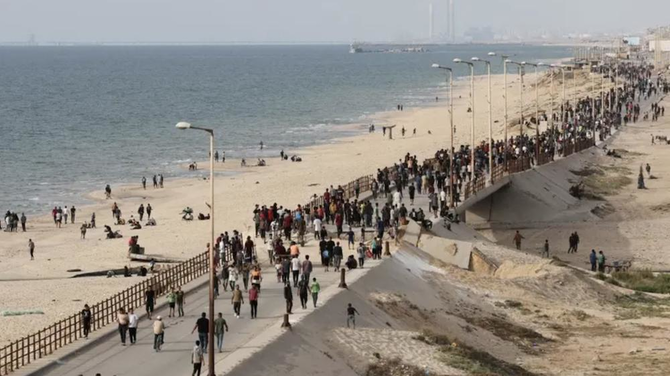 Palestinians gather in the hope of obtaining aid delivered into Gaza through a US-built pier, amid the ongoing conflict between Israel and Hamas, as seen from central Gaza Strip, May 19, 2024. (Reuters)