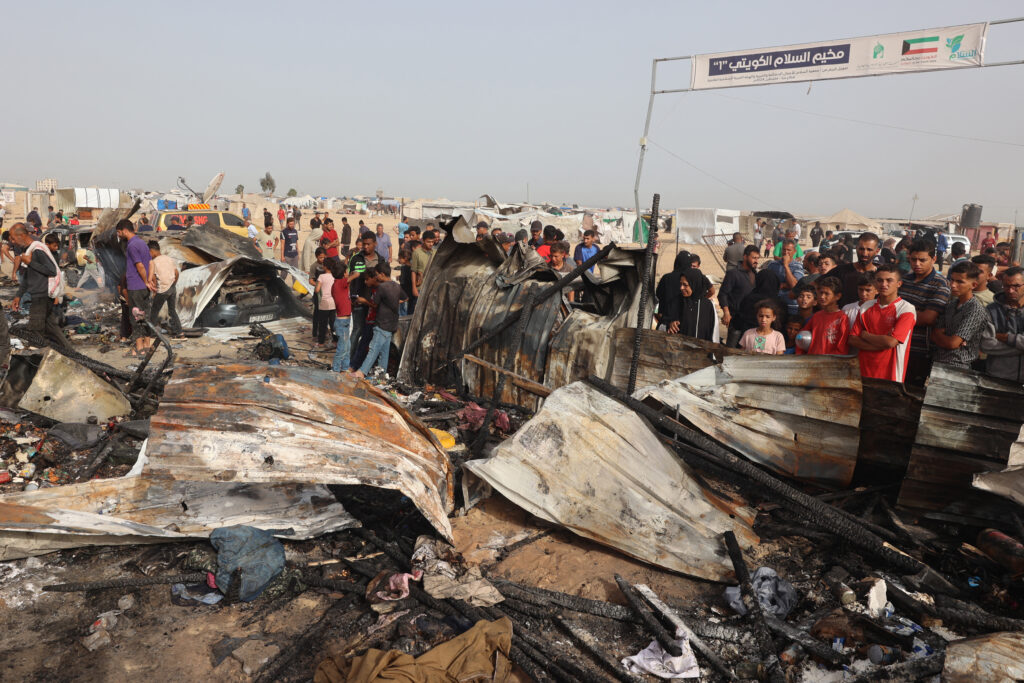 Palestinians gather at the site of an Israeli strike on a camp for internally displaced people in Rafah on May 27. (AFP)