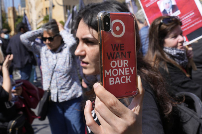 A protester depositor shows her mobile phone that she films with during a protest outside a Bank Audi branch in downtown Beirut on May 9, 2023. (AP/File)