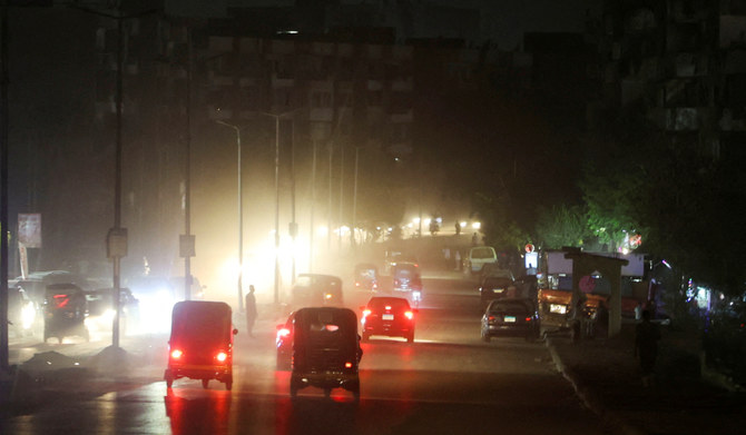 A general view shows vehicles and people walking through dark roads as power cuts to reduce energy consumption are executed by the Egyptian government during the current brutal heat wave, in Cairo, Egypt August 3, 2023. (REUTERS)