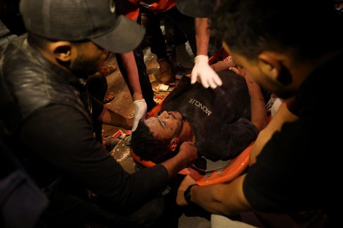 Palestinian civil defense and local residents evacuate a wounded man from the destroyed Al-Qadri house which was struck by Israeli bombardment in Rafah in the southern Gaza Strip amid the ongoing conflict between Israel and the militant group Hamas. (AFP)