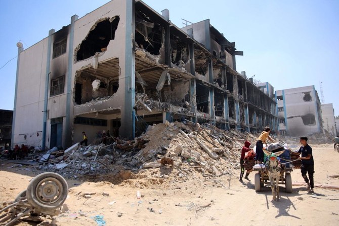 Palestinians transport some of their belongs that they salvaged from a damaged UN-run school in the Jabalia refugee camp in the northern Gaza Strip after they returned briefly with others to check on their homes on May 31, 2024. (AFP)