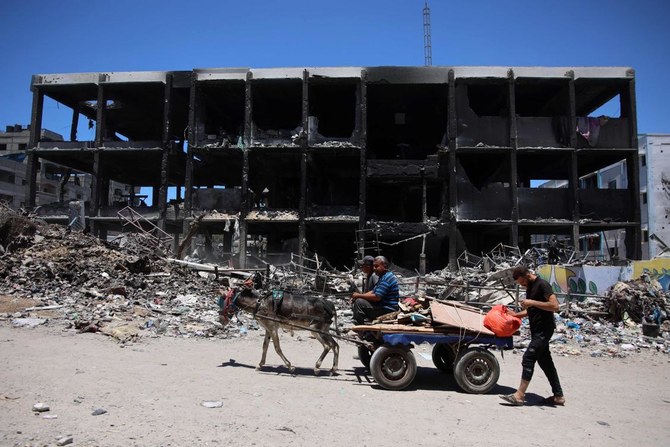 Palestinians transport some salvaged belongings as they leave the Jabalia refugee camp in the northern Gaza Strip after they returned briefly to check on their homes on May 31, 2024. (AFP)