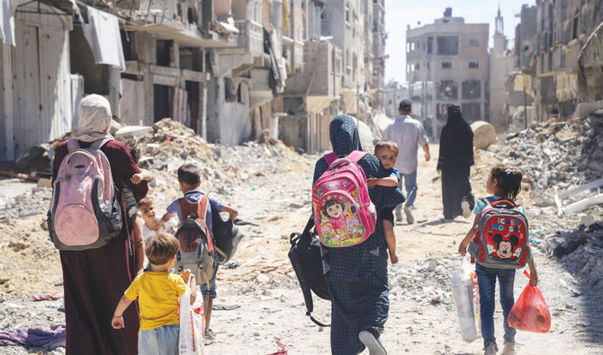 Palestinian women and their children walk through destruction in the wake of an Israeli air and ground offensive in Jebaliya, northern Gaza Strip. (AP)
