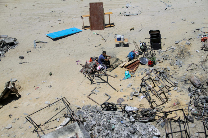 A displaced Palestinian boy sits next to belongings at a school he returned to with his family, after the school was badly damaged in an Israeli raid, in Jabalia refugee camp in the northern Gaza Strip, June 2, 2024. (Reuters)