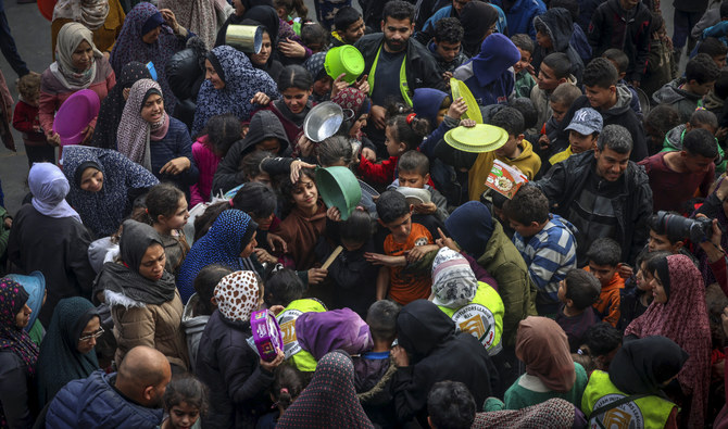 Displaced Palestinians gather to receive food at a government school in Rafah in the southern Gaza Strip on February 19, 2024. (AFP/File)