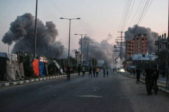 Palestinians watch smoke billowing after an Israeli airstrike in Deir al-Balah in the central Gaza Strip on June 6, 2024, amid the ongoing conflict between Israel and Hamas. (AFP)