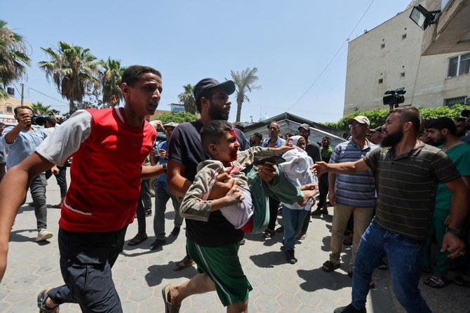 A Palestinian man carries a casualty in the aftermath of an Israeli strike at Al-Aqsa Martyrs Hospital in Deir Al-Balah, in the central Gaza Strip, on Jun. 8, 2024. (Reuters)