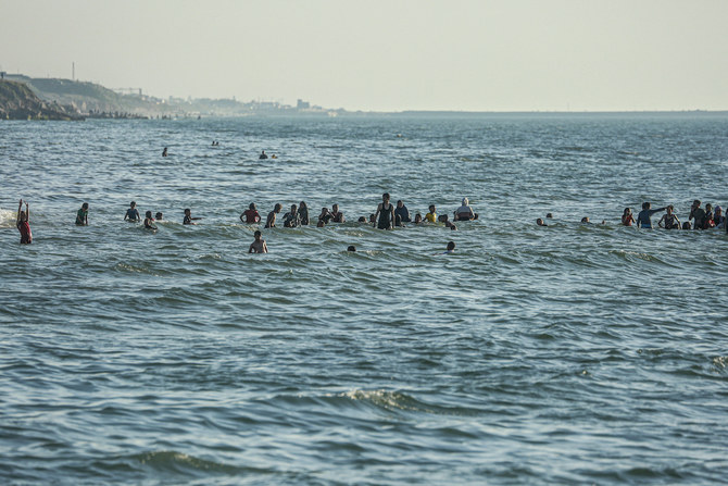 Palestinians swim in the sea in Deir el-Balah in the central Gaza Strip on April 17, 2024. (File/AFP)