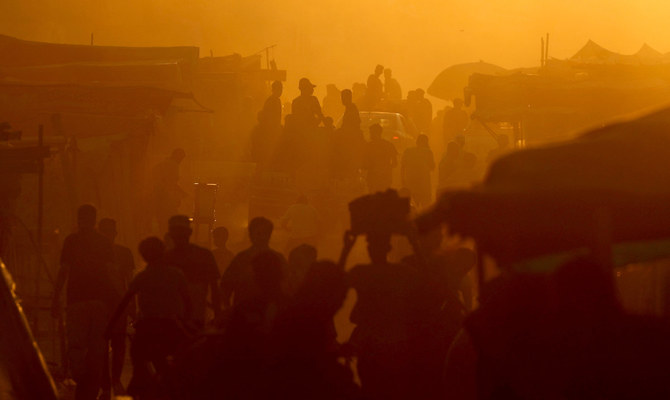 Palestinians walk and travel along a street, in an area where houses have been destroyed in Israeli strikes, amid the Israel-Hamas conflict, in Khan Younis, in the southern Gaza Strip, June 9, 2024. (Reuters)