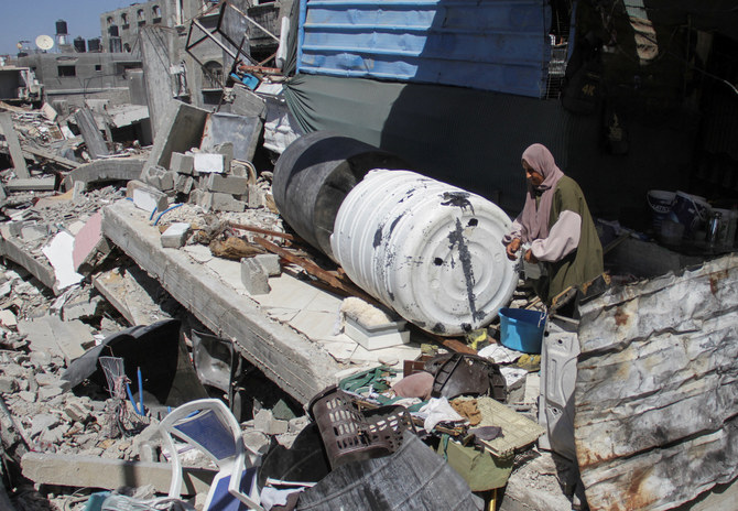 A Palestinian woman stands among the rubble of a damaged building, which was destroyed during Israel’s military offensive in Beit Lahia in the northern Gaza Strip, June 12, 2024. (Reuters)