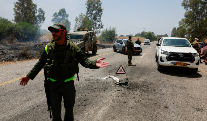 Members of Israeli forces secure the road following a rocket attack from Lebanon, amid ongoing cross-border hostilities between Hezbollah and Israeli forces, near Kiryat Shmona, northern Israel, June 14, 2024. (REUTERS)