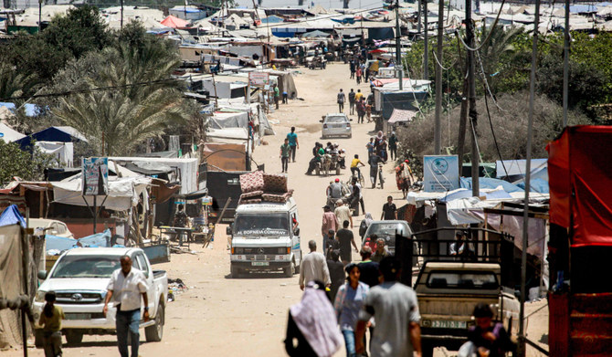 Vehicles move past the tents and shelters of people displaced by conflict in the western part of Rafah in the southern Gaza Strip on Friday. (AFP)
