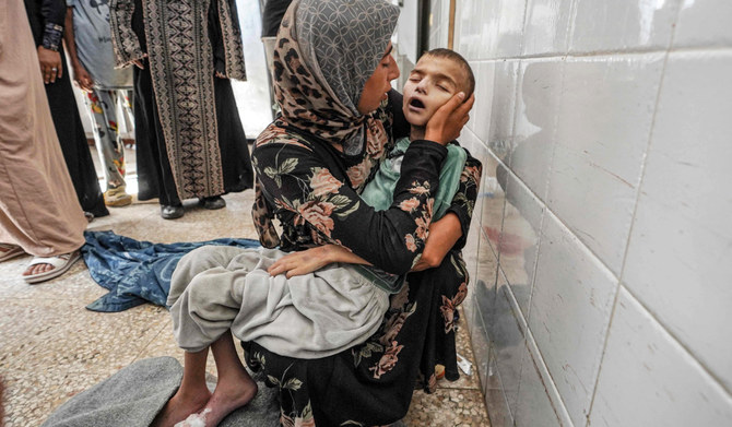 The body of Eyad Hegazi, a 10-year-old Palestinian child suffering from malnutrition and displaced from Shejaiya, rests in the arms of his mother after he died at the Aqsa Martyrs hospital in Deir el-Balah in the central Gaza Strip on June 14, 2024 amid the ongoing conflict in the Palestinian territory between Israel and Hamas. (AFP)