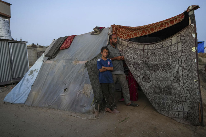 Abdelsattar al-Batsh stands with his son ahead of the Eid al-Adha holiday in Deir al Balah, Gaza Strip, Tuesday, June 11, 2024. They were displaced from their home by the war between Israel and Hamas. (AP)