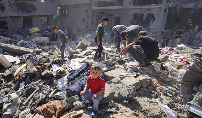 Palestinian residents search the rubble of a family home destroyed in Israeli strikes in the central Gaza Strip on Tuesday. (AFP)