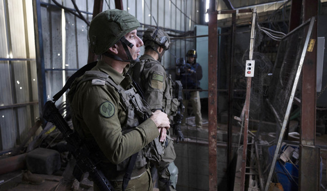 In this picture taken during a media tour organized by the Israeli military on January 8, 2024, Rear Admiral Daniel Hagari, Israeli military spokesperson, shows what the army claims is a Hamas rocket factory in al-Bureij, in the central Gaza Strip. (AFP)